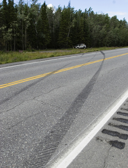 This is a photo of skid marks on a road from a car that was braking and stopped off the side of the road.