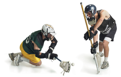 This is a photo of two male lacrosse players from opposing teams. One confronts the other to steal a pass.