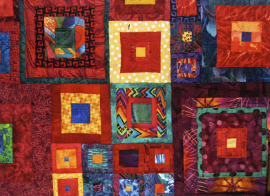 This is a photo of a colourful quilt with square designs.