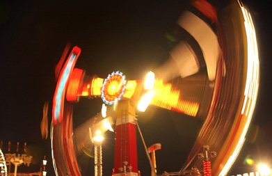 This is a motion-blurred photo of an amusement park ride at night.