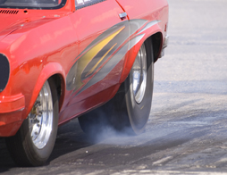 This is a photo showing smoke from the tires of a car taking part in a drag race. 