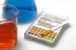 This is a photo of solutions with a pH indicator strip.