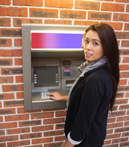 This is an image of a person using a bank machine.