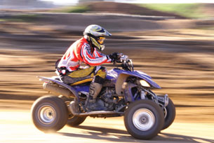 A photograph shows a quad moving at high speed.