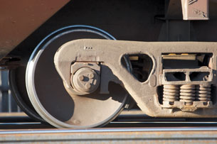 A photo shows a close-up of a locomotive wheel on a train track.