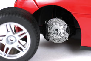 A photo shows a close-up of a vehicle with its tire removed to reveal the vehicle’s brakes.