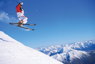 A photograph shows a downhill skier with skis off the ground.