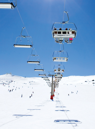 A photographs shows a quad chairlift at a ski hill.