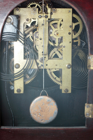 A photograph shows a pendulum and the inner workings of a clock.
