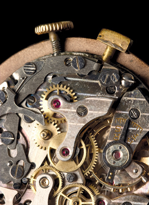 The inside of a watch, with gears and components, is shown in this photograph.