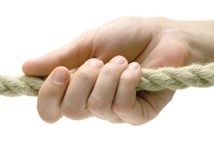 A photograph shows one hand pulling on a rope.